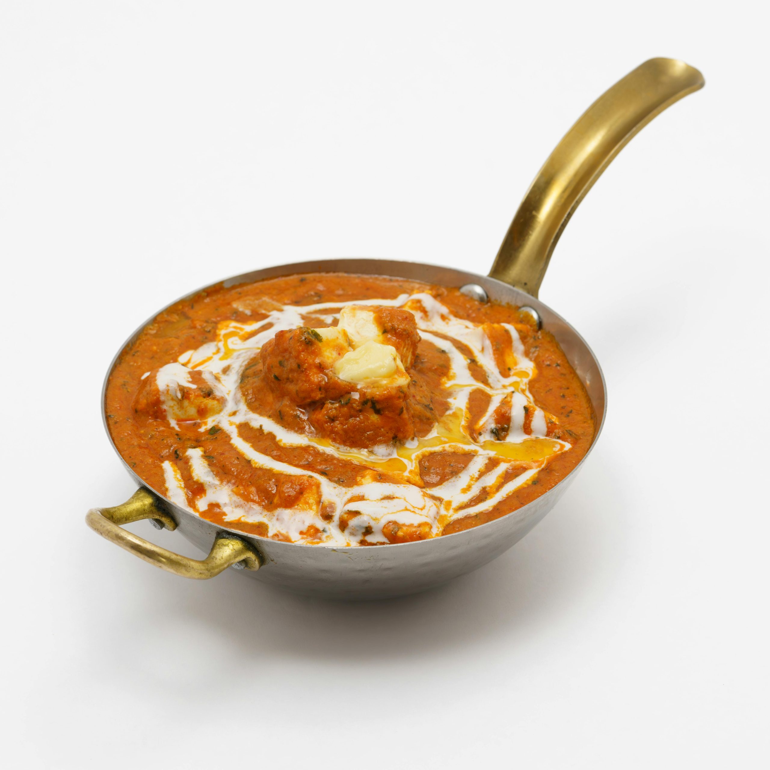 Creamy Indian butter chicken served in a traditional copper pan, garnished with cream and butter. Perfect for culinary themes.
